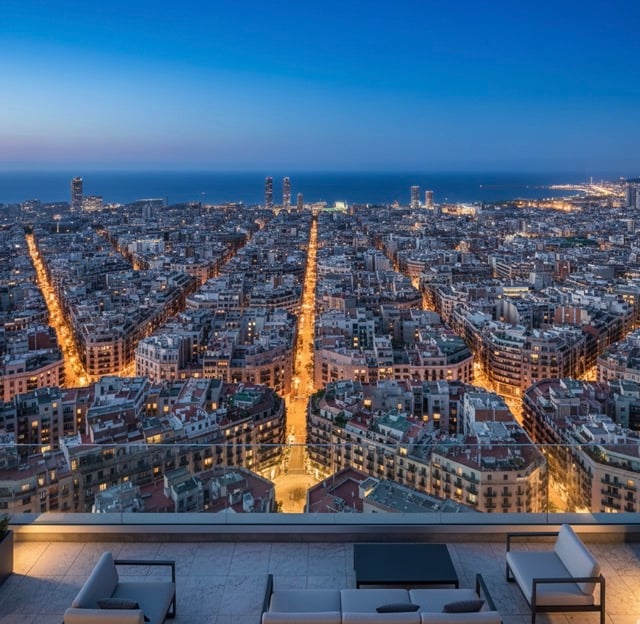 Aerial view of Barcelona Eixample district at dusk showing urban grid pattern with luxury penthouse terrace in foreground
