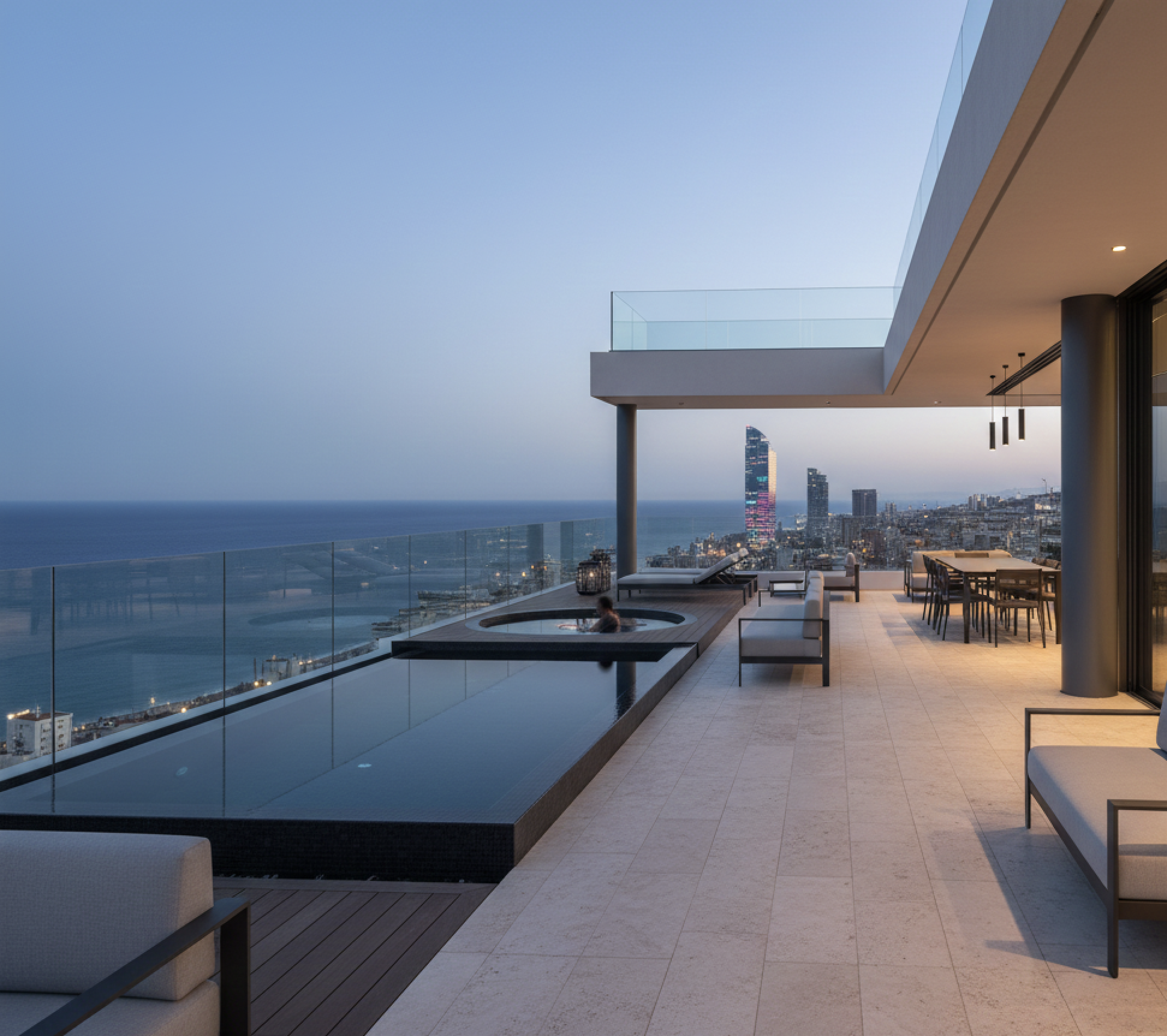 Contemporary luxury penthouse terrace in Diagonal Mar Barcelona with Mediterranean views and Barcelona skyline at dusk