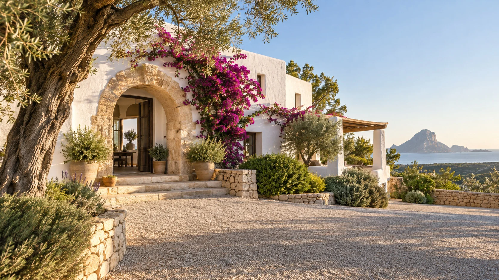 The arched entrance of a renovated Ibizan country house with bougainvillea.